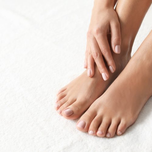 Woman with beautiful feet on white towel, closeup. Spa treatment